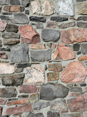 Stonework wall in rows with mortar in many colors