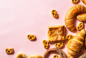 Miscellaneous types of pastry on pink background.
