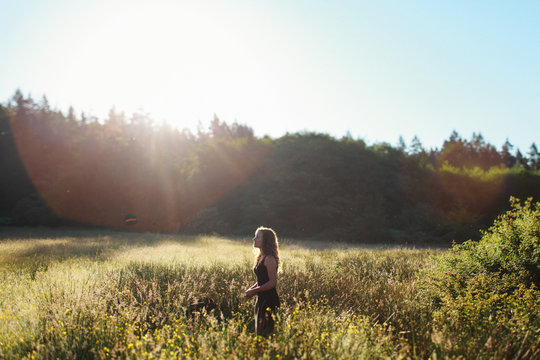 Young woman standing in field in morning light