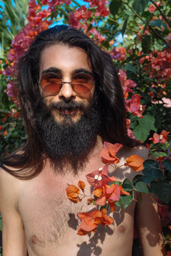 Man Standing by a Flower Bush