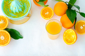 Freshly squeezed orange juice in turquoise juicer on white background