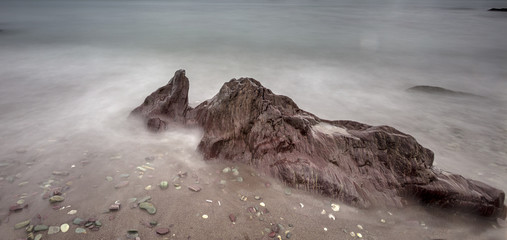 Obraz premium Rocks on seashore - long exposure, sea movement