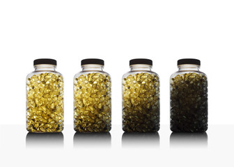 Amber glow through bottles full of fish oil omega 3 and vitamin D supplement gel capsules. on white...