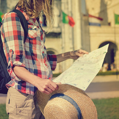 Close up detail of tourist traveler hands holding city map on sunny day outdoors background. Person having fun exploring abstract landmark tourism lifestyle