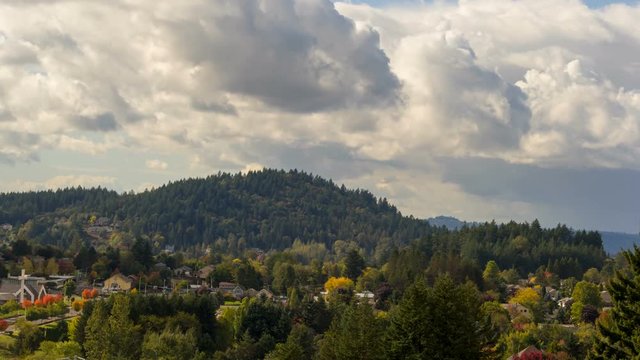 Ultra HD 4k time lapse movie of fast moving white clouds and blue sky over residential suburb homes in Happy Valley Oregon and Mt. Talbert early fall season 4096x2304