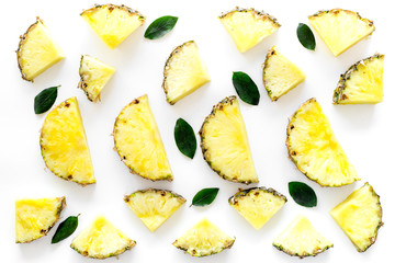 Pinneapple slices and leaves pattern on white background top view