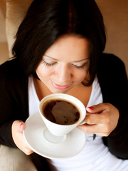 young woman sitting in a cafe drinking coffee