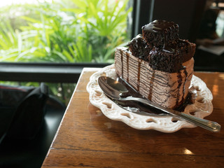Chocolate cake with brownie and vanilla on a white plate on a wooden table at a coffee shop.Selective focus