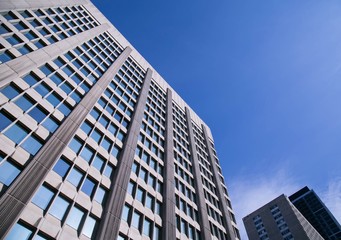 Fototapeta na wymiar Tall corporate office building with blue sky