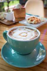 Cappuccino ,Waffle and Honey Toast with banana strawberrie icecream and honey Placed on a table in a coffee shop.High calorie.Dessert for women and Children love