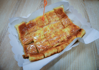 Toasted bread, brown sugar and sweetened condensed milk in a paper tray.