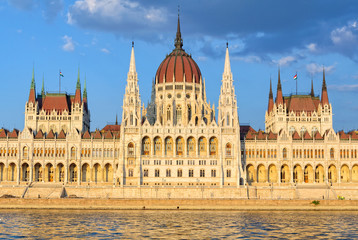 Fototapeta na wymiar The symmetrical main facade and the central dome of the Hungarian Parliament Building overlook the River Danube - Budapest, Hungary