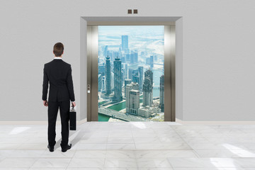 Businessman With Briefcase Looking At Modern Elevator