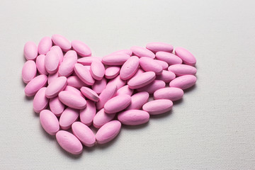 Obraz na płótnie Canvas Many pink tablets pills in heart shape