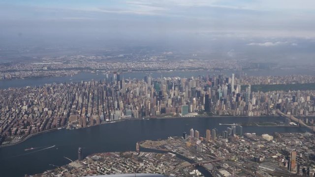 A daytime aerial establishing shot of the the buildings on Manhattan island.  	