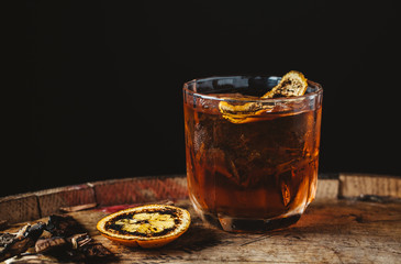 Smoked old fashioned cocktail on dark wooden background