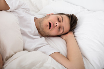 Obraz na płótnie Canvas Tired Young Man Snoring
