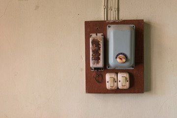 vintage switches and ceiling fan control on wooden box at dirty wall, copy space. old technology...