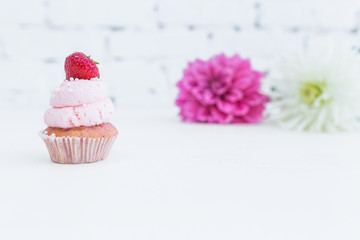 Cupcake with with fresh strawberries flowers.