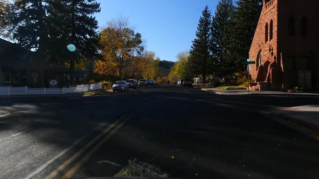 Driving point of view through a traditional small town in America in Autumn