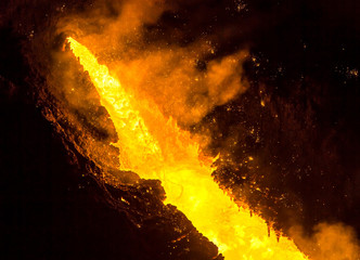 Tapping the Blast Furnace - liquid molten iron puring out of the taphole of a blast furnace