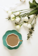 Holiday concept. Cup of cocoa, bouquet of white flowers on white background. Top view. Copy space