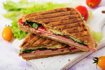 Club sandwich panini with ham, tomato, cheese and lettuce