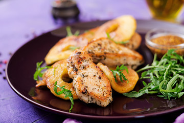 Chicken fillet with apples cooked on grill.