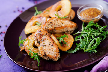 Chicken fillet with apples cooked on grill.