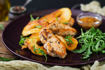 Chicken fillet with apples cooked on grill.