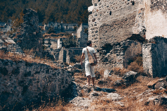 young man traveller in old town ruins