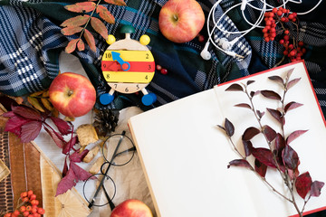 Fresh Pastry Bun, Cup of hot coffee and autumn leaves on wooden background. Wooden letters word AUTUMN. Top view, copy space