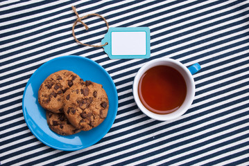 Top view blue set cup and plate with cookies with chocolate, and free label. Space for text, note.Food concept.
