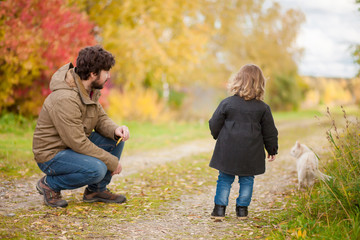 Fototapeta premium Father and daughter walking together with cat.