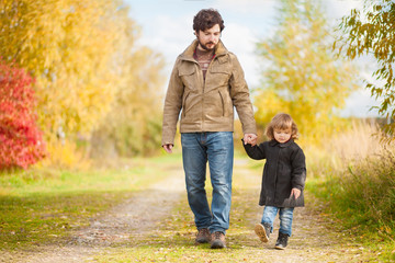 Fototapeta premium Father and daughter walking together, autumn day.