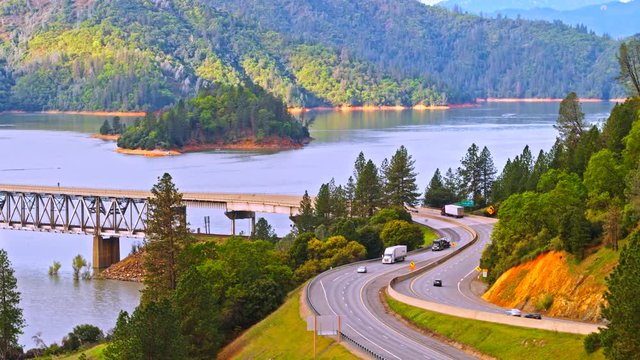 Vehicles driving on Pit River Bridge double deck road and rail bridge over Shasta Lake in Shasta County, California, with Interstate 5 on upper and Union Pacific Railroad on lower deck