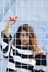 woman leaning behind the lattice