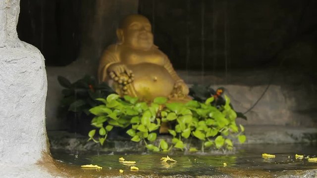 Golden Buddha statue in little pond with water stream. Golden mount (Wat Saket) Bangkok Thailand.