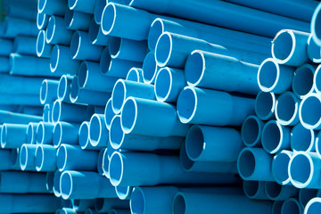 Selective focus of blue PVC pipes in warehouse