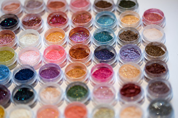 Cosmetics. Pigments for make-up, eyes, lips, face and body. Brilliant radiant, scattered multicolored powders.