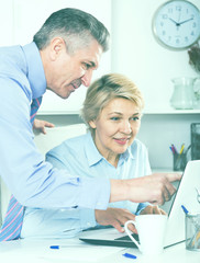 Obraz premium Mature man helping his colleague