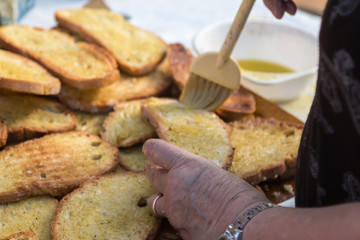 Preparing Slices of Grilled Bread with Olive Oil, Italian Snack