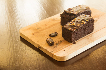 Shock Chocolate brownies with nuts on a wooden floor. 