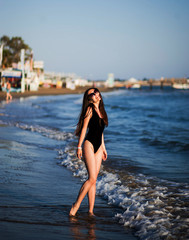 Beautiful girl in a black body by the sea