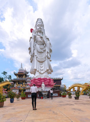Fototapeta na wymiar Dong Nai, Vietnam - October 8th, 2017: Buddhists Praying the buddha in the ancient architectural pagoda with beautiful statues depicting religious spiritual culture in Dong Nai, Vietnam.