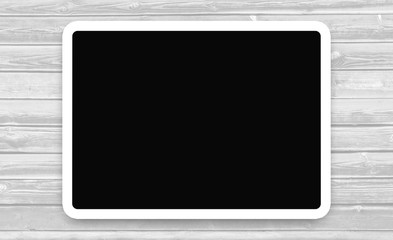 Tablet with the dark screen on wooden background.  White frame with a black background on a wooden Board with copy space for your text.     