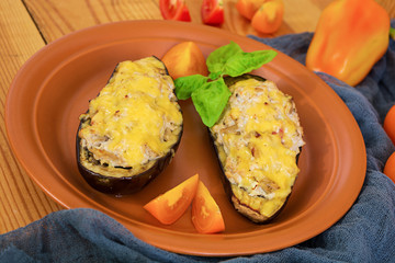 Stuffed eggplant with chicken and vegetables on wooden background