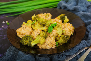Chicken meatballs with broccoli on dark background