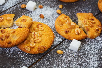 Cookies with peanuts on dark wooden background