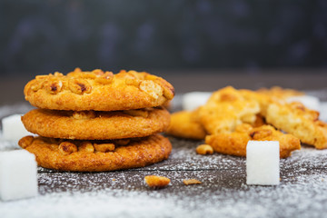 Cookies with peanuts on dark wooden background